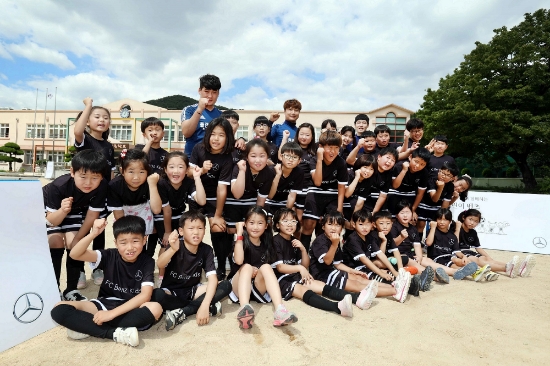 창원 구산 초등학교 학생 35명이 ‘FC 어린이 벤츠’ 축구교실 유니폼을 입고 강사진과 함께 파이팅을 외치고 있다. 사진=메르세데스-벤츠.