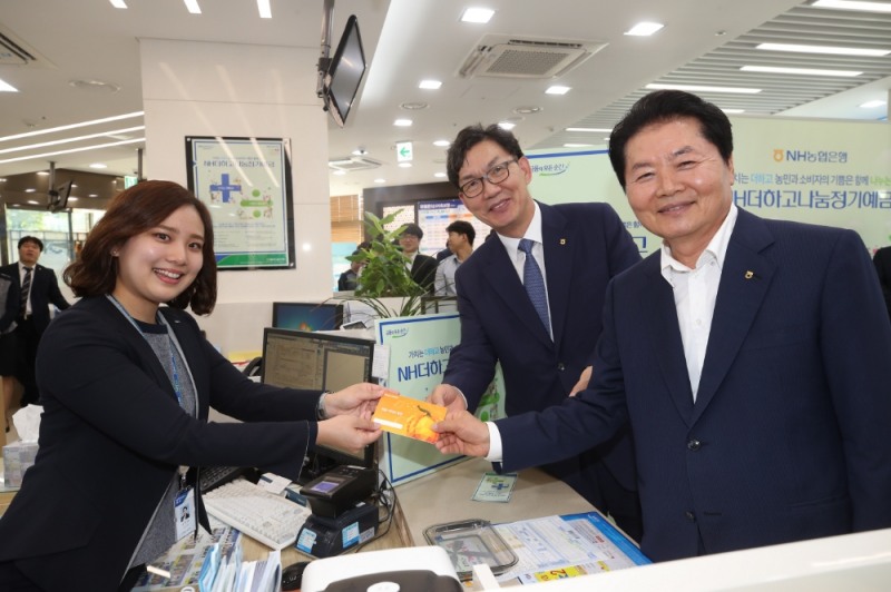김병원 농협중앙회장(가장 오른쪽)이 27일 농협은행 본점 영업부를 방문해 'NH더하고나눔 정기예금' 1호 고객으로 상품에 가입했다. 이후 이대훈 NH농협은행장(가운데), 영업점직원과 함께 기념촬영을 하고 있다. / 사진= NH농협은행