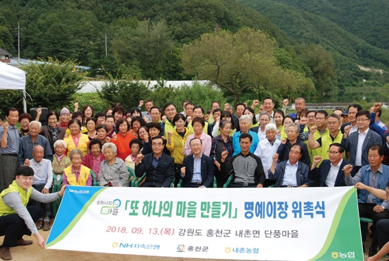 ▲ 김건영 NH저축은행 대표(아랫줄 가운데)와 임직원들이 강원도 홍천군 단풍마을과 ‘또 하나의 마을만들기’ 자매결연을 맺고 기념촬영을 하고 있다. 사진 = NH저축은행