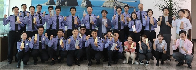지난 8일 부산해양경찰서에서 유라가 선물한 사회적기업 우시산 텀블러를 전달받은 해양경찰들이 기념 사진을 촬영하고 있다. 제공 : SK이노베이션.