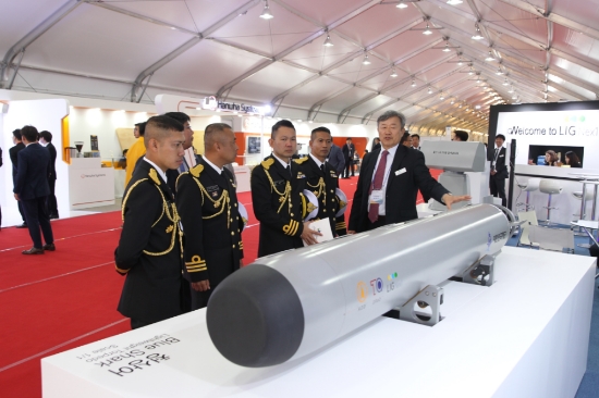 12일 제주 민군복합항에서 개최 중인 ‘2018 국제관함식’에 참가한 군 관계자가 LIG넥스원 홍보부스에서 함대함유도무기, 전술함대지유도탄, 대잠경어뢰 등 대함‧대지‧대잠 작전에 대응할 수 있는 정밀유도무기에 대한 설명을 듣고 있다. 사진=LIG넥스원.