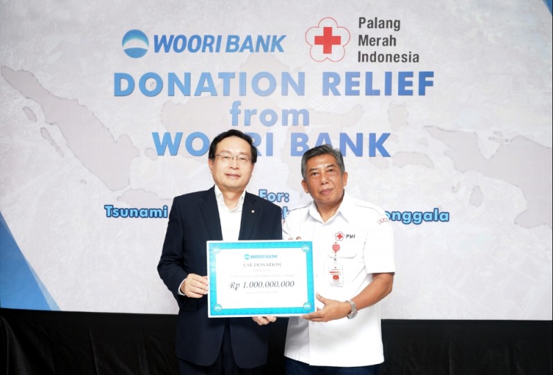 손태승 우리은행장(사진 왼쪽)이 인도네시아 적십자사 발리지부 부지부장에게 성금 10억 루피아를 전달하고 있다. / 사진= 우리은행