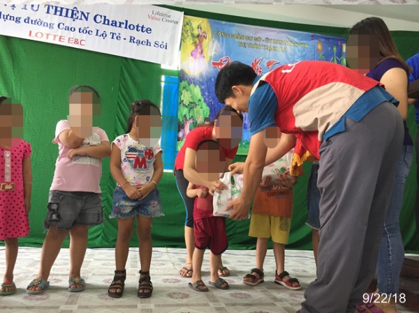 로테-락소이 고속도로 1공구 현장의 샤롯데봉사단이 주민들에게 명절선물을 전하고 있다. 사진=롯데건설.