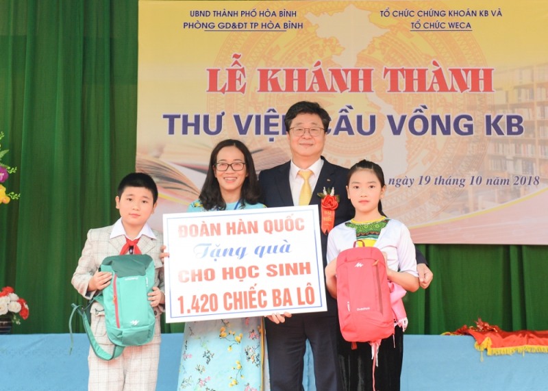 ▲전병조 KB증권 사장(오른쪽 두번째)이 베트남 흐엉우이 초등학교 학생들에게 가방을 전달하고 학생 대표와 기념촬영을 하고 있다./사진=KB증권