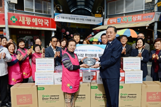 22일 포항 큰동해시장에서 박차훈 MG새마을금고 재단 이사장이 시장 상인에게 ‘MG전통시장 마케팅 지원물품’을 전달하고 있다. / 사진 = MG새마을금고