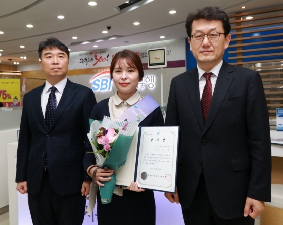▲ 30일 홍명진 SBI저축은행 청담지점 주임(가운데)이 금융감독원이 주관하는 `2018년도 상반기 전기통신금융사기 피해예방` 우수 사례로 선정, 금융감독원으로부터 감사장을 받고 김수헌 금감원 불법금융대응단장(오른쪽), 이명규 금감원 금융사기대응팀장(왼쪽))과 기념사진을 찍고 있다./사진제공=SBI저축은행