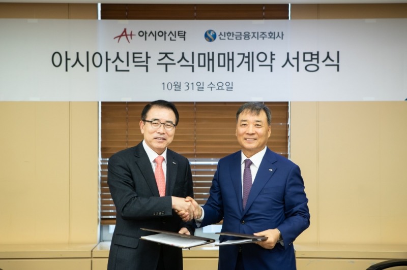 신한금융지주는 31일 서울 강남구 역삼동에 위치한 법무법인 태평양 사무실에서 아시아신탁(주)과 주식매매계약(SPA)를 체결했다. 이날 체결식에서 신한금융그룹 조용병 회장(사진 왼쪽)과 아시아신탁 정서진 부회장이 기념 촬영을 하고 있다. / 사진= 신한금융지주
