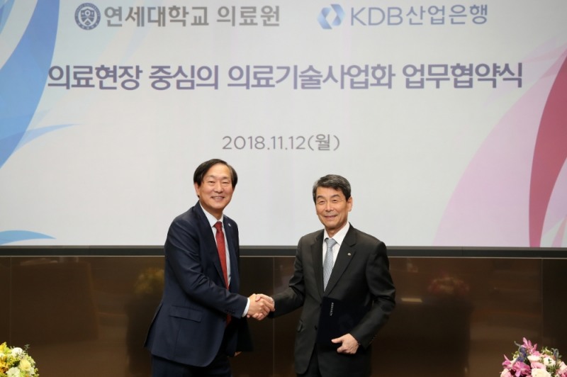 이동걸 산업은행 회장(오른쪽)이 12일 여의도 산업은행 본점 1층 IR센터에서 윤도흠 연세대학교의료원장과 의료현장 중심의 의료기술사업화 촉진을 위한 업무협약을 체결하고 악수를 하고 있다. / 사진= 산업은행