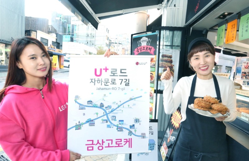 △LG유플러스 직원(좌측)과 서촌마을 고로케 판매점 ‘금상고로케’ 이양옥 사장이 ‘U+로드’를 알리고 있다.