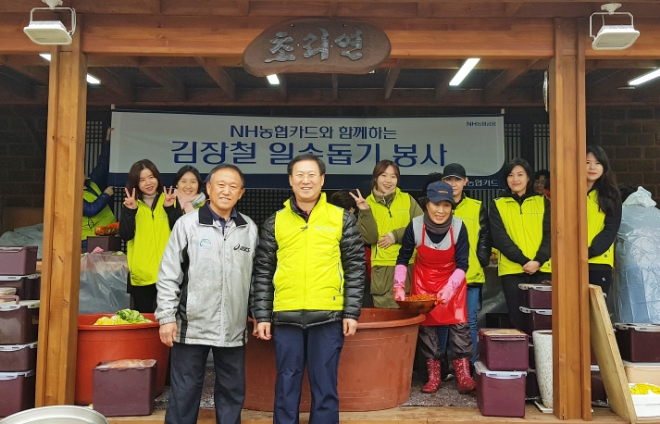 지난 21일 파주 초리골 자매결연마을을 찾은 우광혁 NH농협카드 부사장(앞줄 오른쪽)과 임직원, 마을 주민들이 김장을 담그며 기념촬영을 하고 있다. / 사진 = NH농협카드