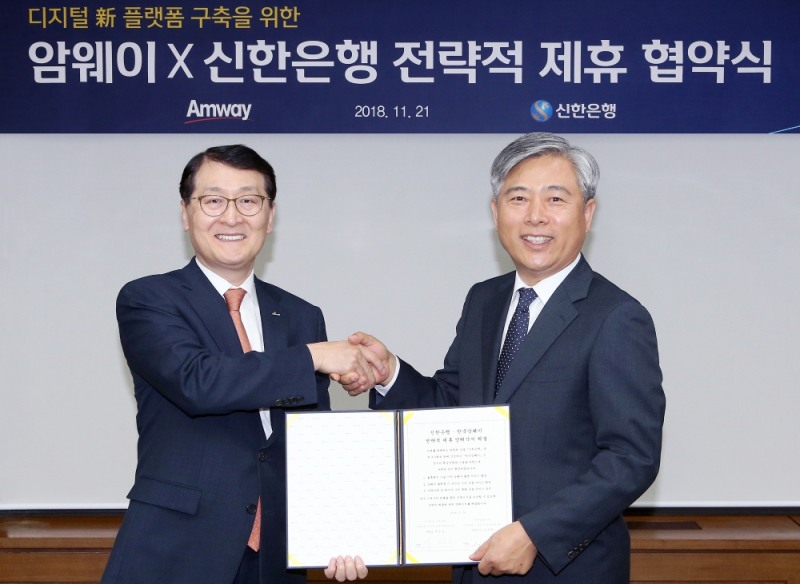 신한은행은 21일 서울 중구 세종대로 소재 본점에서 한국암웨이와 새로운 디지털 생활 금융 플랫폼 구축을 위한 전략적 업무협약을 체결했다. 신한은행 위성호 행장(왼쪽)과 한국암웨이 김장환 대표이사(오른쪽)가 협약식을 마치고 기념촬영을 하고 있다. / 사진= 신한은행