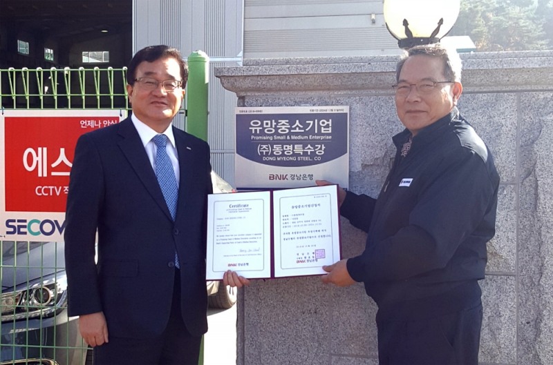 △경남은행 관계자가 동명특수강을 방문해 유망중소기업 인증서와 현판 전달 후 기념촬영을 하고 있다./사진=BNK경남은행