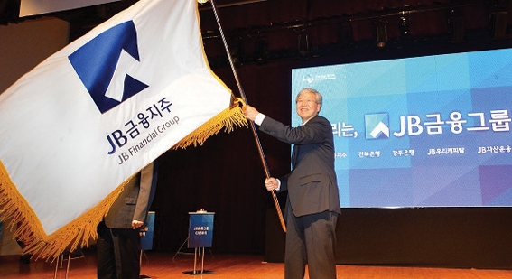 △ 김한 JB금융지주 회장이 2015년 4월 JB금융 통합 CI 선포식에서 깃발을 흔들고 있다. / 사진= JB금융지주