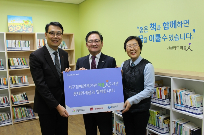 지난 4일 신한카드는 롯데면세점과 함께 부산 ‘양정청소년수련관’과 ‘서구 장애인 복지관’에 아름인 도서관을 개관했다. 허기 롯데면세점 부산점장(왼쪽)과 정광호 신한카드 영남본부장(가운데)이 서구장애인복지관 관계자와 기념사진을 찍고 있다. / 사진 = 신한카드