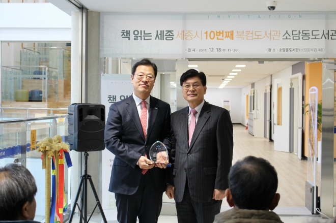 신한카드는 지난 18일 세종시 소담동 복합커뮤니케이션센터에 아름인 도서관을 개관했다고 19일 밝혔다. 최인선 신한카드 부사장(왼쪽)과 이춘희 세종시장(오른쪽)이 기념촬영을 하고 있다. / 사진 = 신한카드