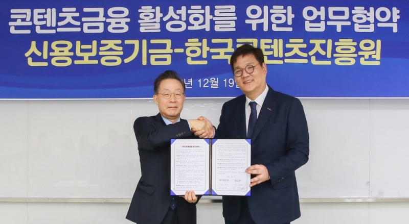 △윤대희 신용보증기금 이사장(왼쪽)이 김영준 한국콘텐츠진흥원 원장(오른쪽)과 함께 19일 서울 중구 한국콘텐츠진흥원 CKL기업지원센터에서 열린 '콘텐츠금융 활성화를 위한 업무협약'에서 기념촬영을 하고 있다./사진=신용보증기금