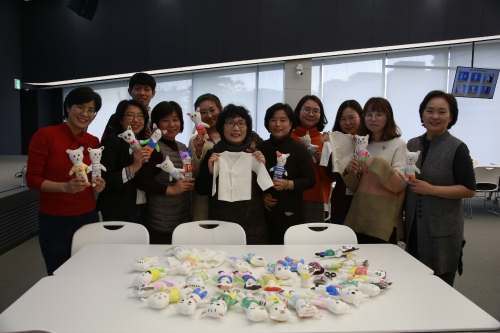 곽경희씨(앞줄 왼쪽부터 네번째)가 코오롱 임직원들과 만든 '신생아 kit'를 들고 있다. 이날 만든 100개의 '신생아 kit'는 해외 입양아동 또는 미혼모 자녀에게 전달될 예정이다. 