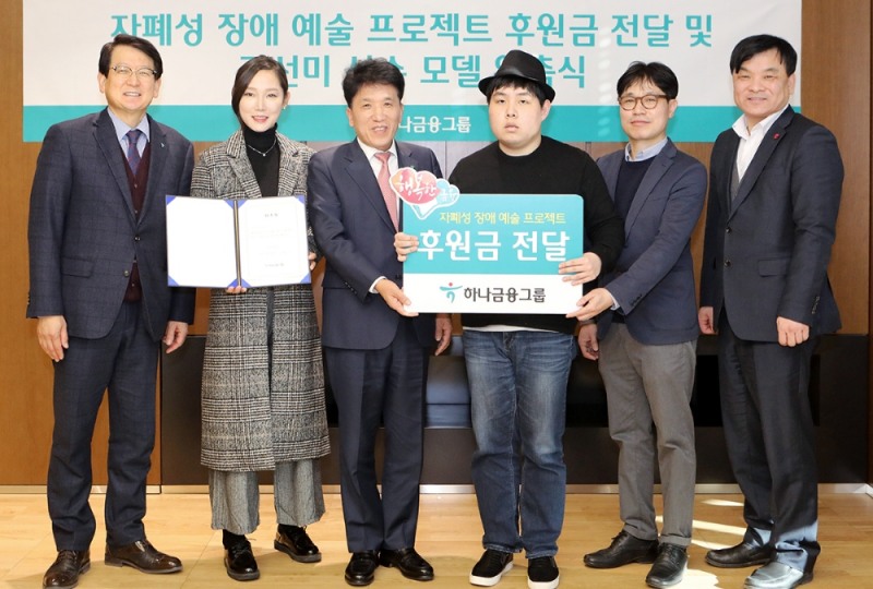 하나금융그룹은 지난 28일 오후 을지로 KEB하나은행 본점에서 2019년 하나금융그룹 캘린더 작품의 작가인 안윤모와 자폐성 장애작가 5인의 예술 프로젝트 지원 후원금을 전달하고 하나금융그룹과 KEB하나은행의 브랜드 모델로 새롭게 발탁된 김선미 장애인 휠체어펜싱 선수에게 위촉장을 전달했다. 사진 왼쪽에서 세번째가 함영주 KEB하나은행장. / 사진= KEB하나은행