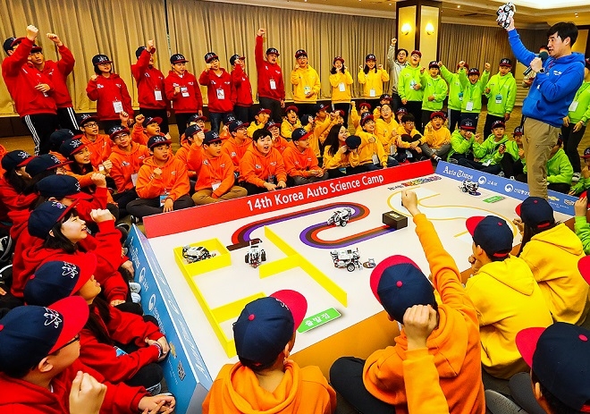 오토사이언스 캠프 참가자들이 자율주행차 주행 원리에 대해 설명을 듣고 직접 코딩한 교육용 자율주행차로 경연을 펼치고 있다. (사진=한국지엠)
