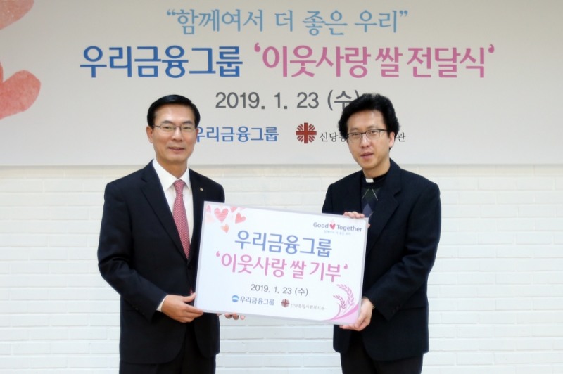 최동수 우리금융지주 부사장(왼쪽)이 신당종합사회복지관에서 '이웃사랑 쌀 전달식' 후 오대일 신당종합사회복지관 관장과 기념 촬영을 하고 있다./사진=우리금융지주