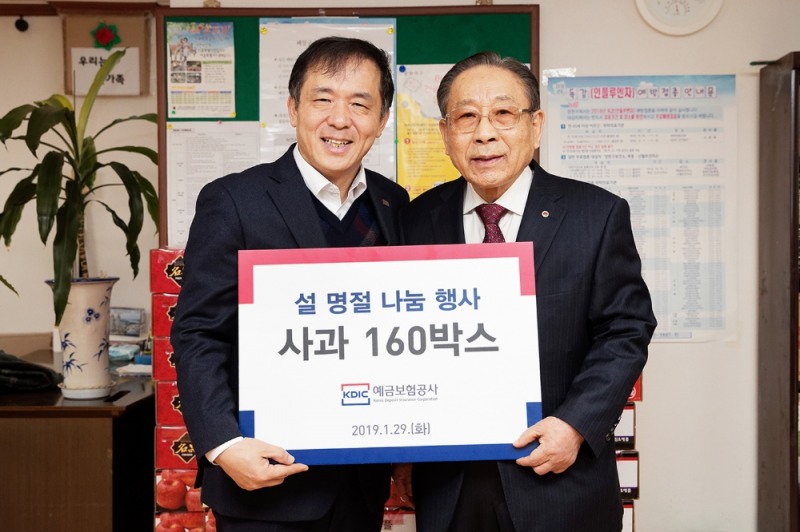 위성백 예보 사장(왼쪽)이 29일 서울 양천구에 위치한 마장경로당을 방문하여 어르신들이 따뜻한 설 명절을 보내실 수 있도록 인근 전통시장에서 구입한 과일 등 후원물품을 전달한 후 기념촬영을 하고 있다./사진=예금보험공사