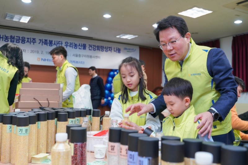 19일 서울시 중구 쌍림동 소재 중구자원봉사센터에서 진행된 'NH농협금융 우리농산물 건강희망상자 나눔 봉사활동'에서 김광수 회장(오른쪽 첫번째)이 가족봉사단으로 참여한 임직원 자녀들과 우리농산물로 꾸린 건강희망상자를 만들고 있다./사진=NH농협금융지주