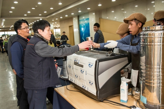 SK인천석유화학 구성원들이 21일 인천에서 열린 ‘1% 나눔, 1% 행복’ 커피 나눔 이벤트 현장에 방문해 발달장애인 바리스타들로부터 커피를 받고 있다. (사진=SK이노베이션)