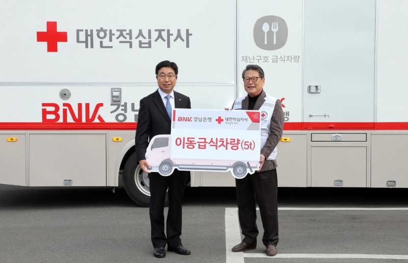 BNK경남은행 황윤철 은행장(사진 왼쪽)이 대한적십자사 경남지사 김종길 회장에게 ‘이동 급식차량 기증서’를 전달하고 있다./사진=BNK경남은행