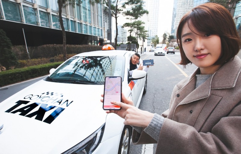 △고요한 택시 기사와 SKT 홍보 모델이 청각장애 택시 기사를 지원하는 티맵택시 앱을 홍보하고 있다/사진=SKT
