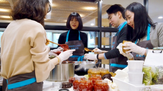 지난 20일 종로노인종합복지관에서 진행된 '사랑의 장 담그기' 행사에서 우리카드 임직원들이 참여해 전통 장을 만들고 있다. / 사진 = 우리카드