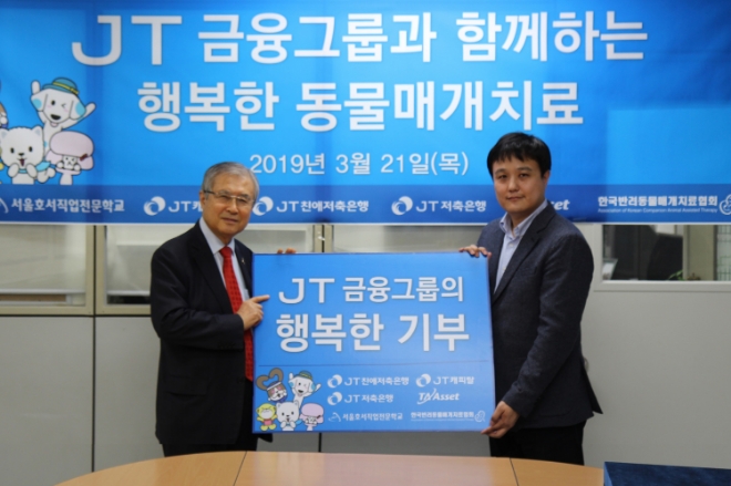 JT친애저축은행 마케팅전략부 조승진 부서장(오른쪽)과 서울호서전문학교 이운희 학장(이사장)이 지난 21일 서울호서직업전문학교를 방문해 공식 캐릭터 ‘쩜피’ 이모티콘 판매 수익금 전액을 후원금으로 전달하고 기념사진을 촬영하고 있다. / 사진 = J트러스트그룹