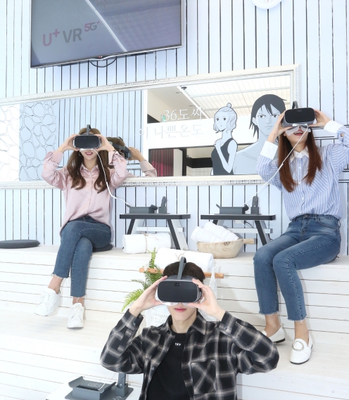 △LG유플러스 모델들이 일상로 5G길에서 VR로 웹툰 작품 목욕의 신을 즐기고 있다/사진=LG유플러스
