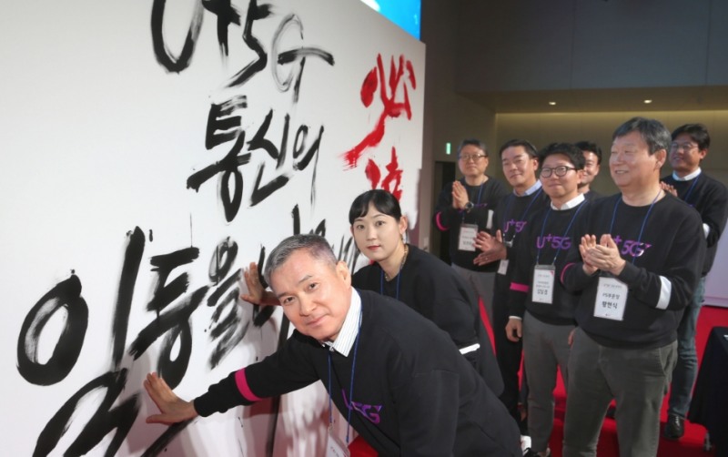 △하현회 LG유플러스 부회장이 지역 대리점 대표 점장들과 5G 붓드로잉 퍼포먼스 작품에 손도장을 찍고 있다/사진=LG유플러스