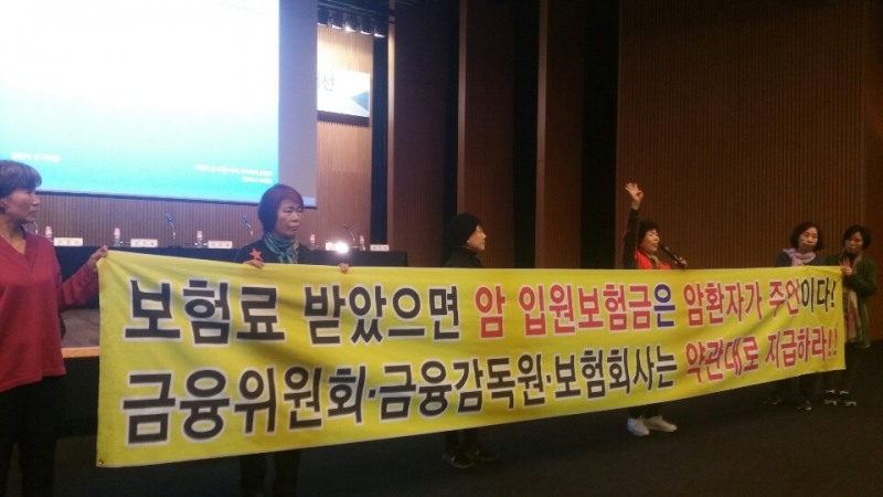 △지난해 4월 열린 16일‘소비자 보호를 위한 보험상품 사업비 및 모집수수료 개선' 공청회 시작을 앞두고 암 환우들이 플래카드를 펼친채 시위를 벌였다. / 사진=한국금융신문