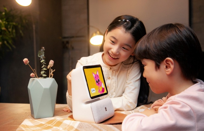 △SK텔레콤 모델들이 보이는 AI 스피커를 통해 핑크퐁 콘텐츠를 보는 모습을 시연하고 있다/사진=SKT