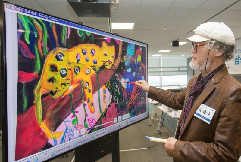 △김종수 한국미술협회 부이사장이 23일 서울 서초동에 위치한 삼성생명 대강의장에서 삼성 QLED 8K TV를 활용해 삼성생명이 주최하는 '제39회 청소년 미술대회' 예선 작품을 심사하고 있다/사진=삼성전자