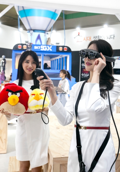●SK텔레콤 모델이 '매직리프' 사의 AR 글래스를 착용하고 인기게임 ‘앵그리버드’를 즐기는 모습. AR 글래스를 활용하면 이용자 눈앞의 공간이 게임 플레이 화면으로 변화해 마치 현실세상에서 게임을 즐기는 것처럼 느낄 수 있다/사진=SKT
