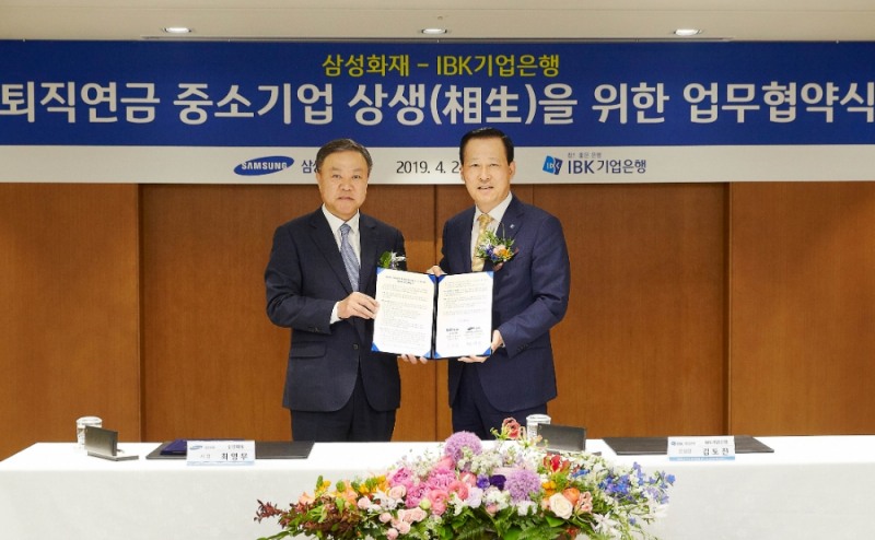 24일 을지로 기업은행 본점에서 김도진 기업은행장(오른쪽)과 최영무 삼성화재 사장(왼쪽)이 협약식을 마치고 기념촬영을 하고 있다. / 사진= 기업은행