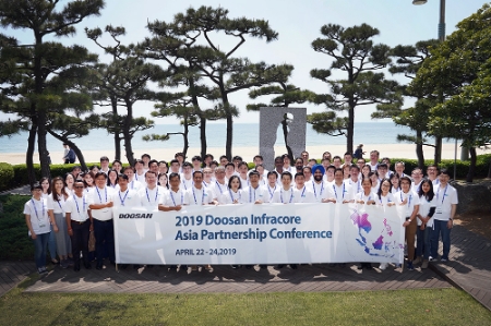 두산인프라코어가 지난 4월 22일부터 사흘간 부산에서 개최한 아시아 건설기계 딜러 미팅에서 참석자들이 기념촬영을 하고 있다.(사진=두산인프라코어)
