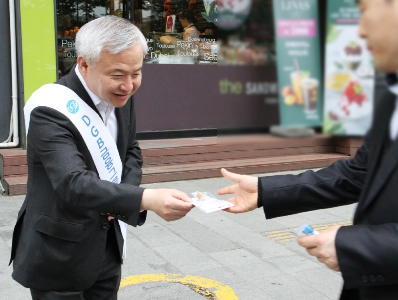 ▲김경규 하이투자증권 김경규 사장이 25일 오전 서울 여의도역 인근 지역에서 출근길 시민들에게 씨드볼을 전달하고 있다./사진=하이투자증권