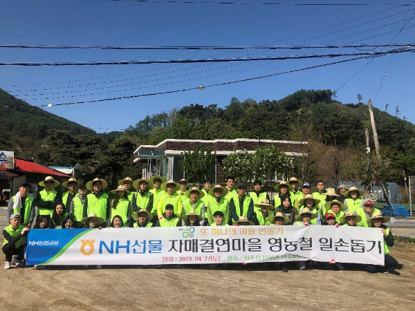 ▲지난 27일 영농철 일손돕기에 나선 NH선물 이성권 대표이사와 임직원은 60여명이 기념촬영을 하고 있다./ 사진=NH투자증권