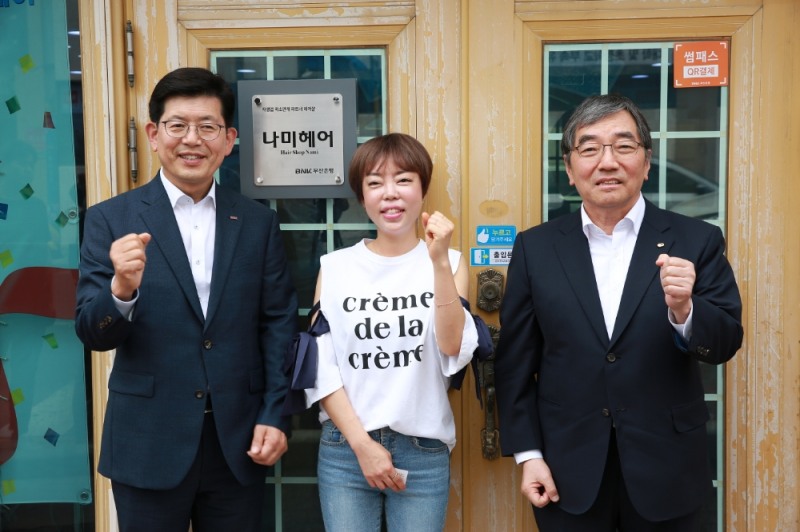 빈대인 부산은행장(왼쪽), 윤석헌 금감원장(오른쪽)이 부산은행 자영업 종합지원센터에서 경영컨설팅을 받은 나미헤어를 방문 후 기념촬영을 하고 있다./사진=금융감독원