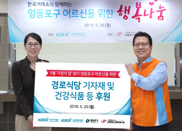 ▲정지원 한국거래소 이사장(오른쪽)이 행복나눔 배식봉사활동에 앞서 박영숙 영등포노인종합사회복지관 관장에게 경로식당 기자재 및 건강식품 등 물품후원을 전달하고 있다./사진=한국거래소