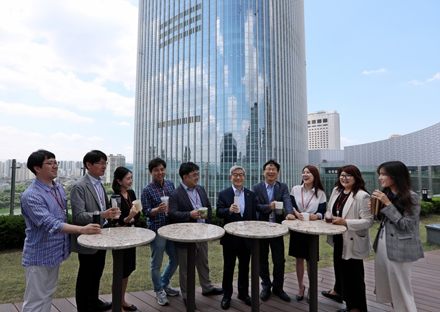 송용덕 부회장이 롯데월드타워를 배경으로 롯데그룹 호텔&서비스BU 임직원들과 함께 머그컵, 텀블러를 사용하며 담소를 나누고 있다. /사진제공=롯데호텔