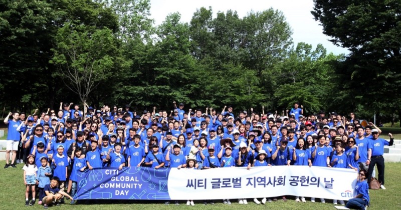한국씨티은행 임직원과 가족들이 8일 오전 전국 25개 현장에서 2000여명이 서웊숲에서 생태계교란식물 제거, 잔디밭 잡초 제거, 튤립 구근과 정원 정리하기, 물길 청소하기 등을 한 후 기념사진을 촬영하고 있다./사진=한국씨티은행