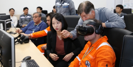 대우조선해양 관계자가 LNG운반선 선원에게 VR 선원교육시스템을 설명하고 있다. (사진=대우조선해양)
