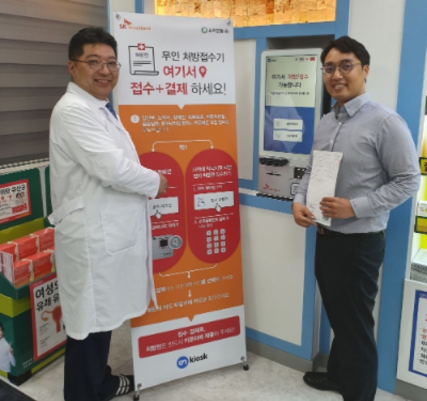 △약사와 온라인팜 관계자가 SK브로드밴드의 약국 전용 키오스크 서비스 온키오스크 출시를 홍보하고 있다/사진=SK브로드밴드