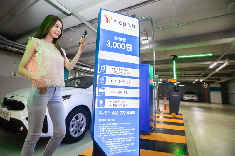 △SK텔레콤 모델이 T맵 주차 서비스 사용을 시연하고 있다/사진=SK텔레콤