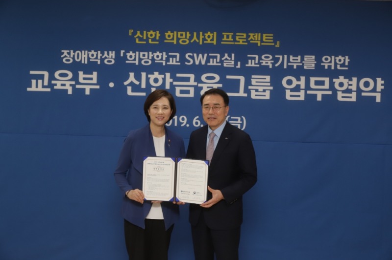 신한희망재단은 21일 서울 마포구에 위치한 한국 우진학교에서 특수학교에 재학 중인 장애학생에게 소프트웨어 교육을 지원하는 '희망학교 SW교실' 사업 추진을 위해 교육부와 업무협약(MOU)을 체결했다. 이날 행사에서 조용병 신한희망재단 이사장(사진 오른쪽)과 유은혜 부총리 겸 교육부장관(사진 왼쪽)이 기념 촬영을 하고 있다. / 사진= 신한금융지주