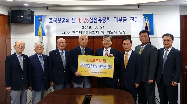 지난 21일 한국대부금융협회 임승보 회장(오른쪽에서 네 번째)과 에이원대부캐피탈 주환곤 대표, 듀오캐피탈대부 강우남 대표가 대한민국6.25참전유공자회 박희모 회장에게 참전유공자 돕기 성금을 전달하고 기념촬영하는 모습. / 사진 = 한국대부금융협회